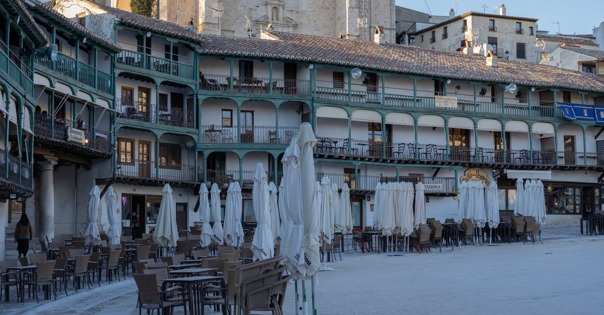 Empty cafe tables in a historic Spanish plaza