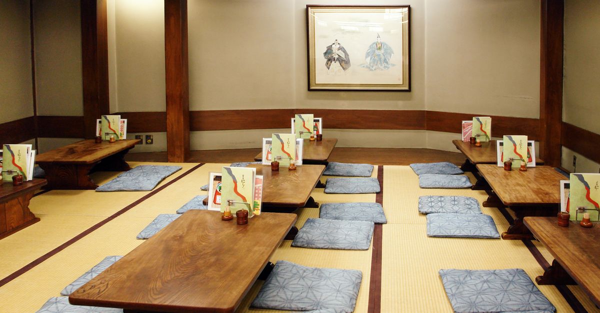 Traditional Japanese ryokan dining room with tatami mats and low tables